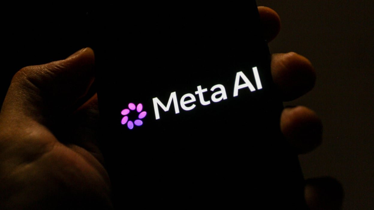 Close up image of a hand holding a smartphone displaying the Meta AI application interface