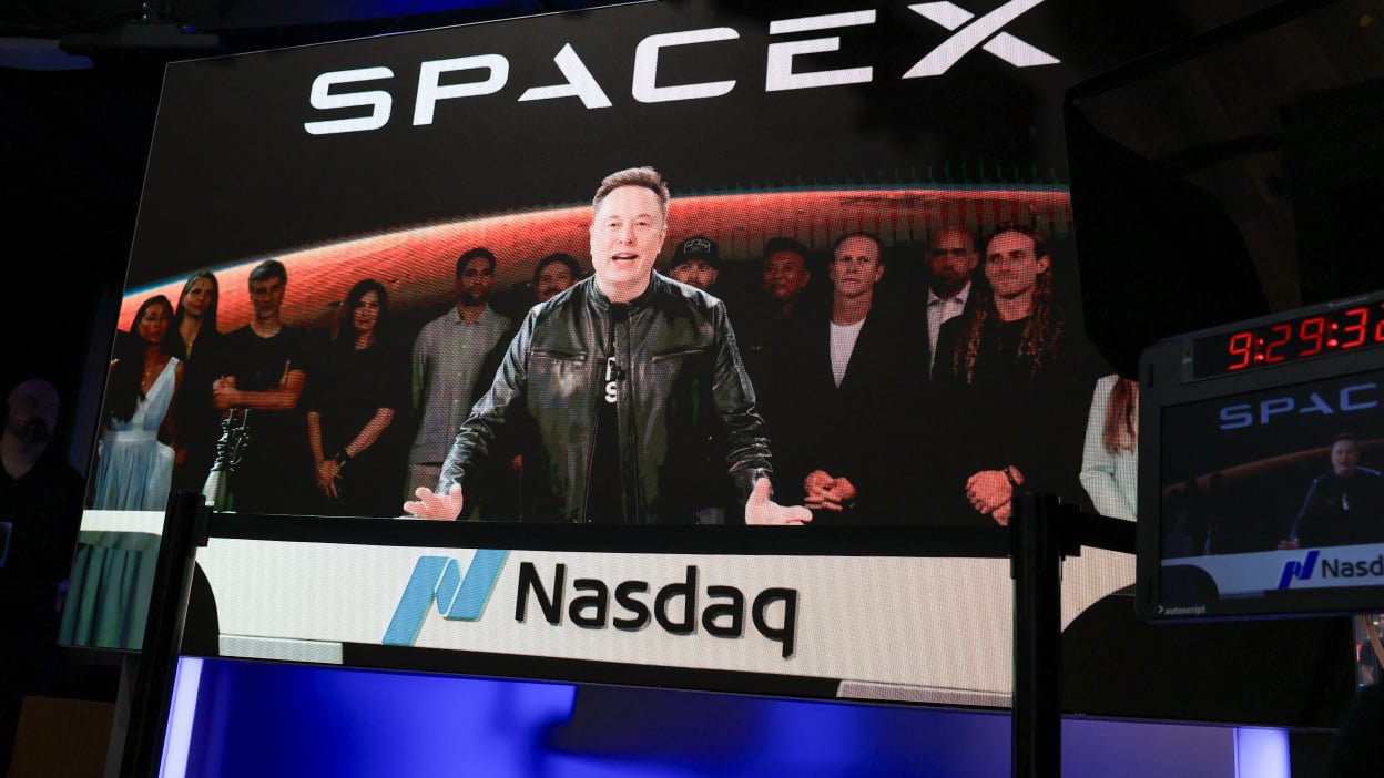Elon Musk, displayed on a screen remotely speaks before the launch of SpaceX