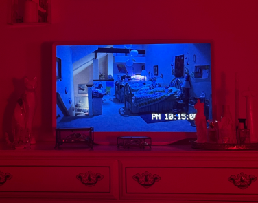 Hisense Déco TV sitting on dresser while playing a scene from "Paranormal Activity 3"
